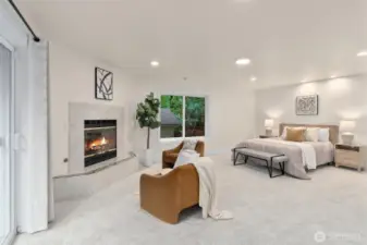 Spacious main-floor primary suite with sitting area and cozy fireplace.