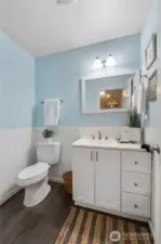 Nicely tucked away, the downstairs powder room has a subway tile surround and updated vanity with storage & upgraded countertop