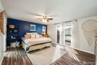 The primary bedroom is HUGE and offers a large slider and deck for enjoying the views. The decorative ceiling fan light circulates the fresh air and cooling A/C