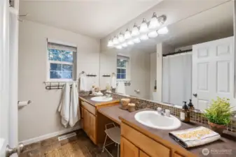 The full bath off the primary bedroom has double sinks, a vanity area and lots of storage & counter space