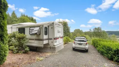 Wide gravel driveway with ample space for two vehicles, offering easy access and convenient parking.