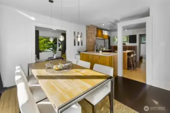 Dining flows into the kitchen—brick accent and wide pass-through make serving and conversation easy.