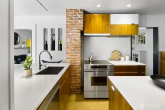 Cook’s kitchen with stainless range, and exposed brick adding warmth and texture.
