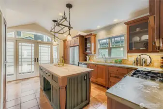 Great Kitchen with so much natural light, rich wood cabinetry, pull out pantry drawers to the left of the refrigerator, and concrete and wood counters. Modern cooking with definite Craftsman flair!