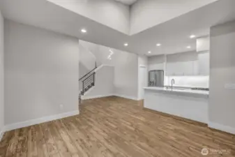 Living room with high ceilings is open to kitchen.