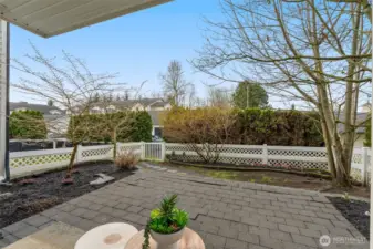 Partially covered patio with garage visible in the background just behind the gate door