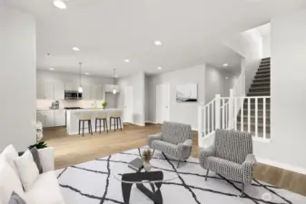 Open concept with living room and kitchen with walk-in pantry. Virtually staged.