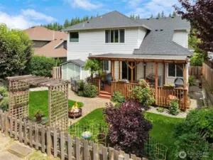Garden beds, covered deck, outbuilding, grassy area and more!
