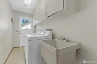 A large Laundry room with cabinetry to stay organized.