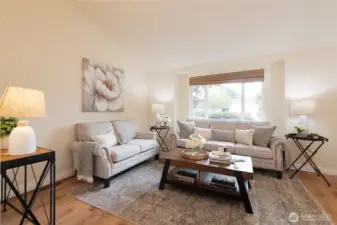Vaulted ceilings elevate the spacious living room, creating a bright and airy atmosphere. Natural light pours in, making this an inviting space for relaxing or entertaining.