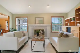 Bright and refined, the formal living room offers a serene retreat with large picture windows framing peaceful green views and filling the space with natural light.