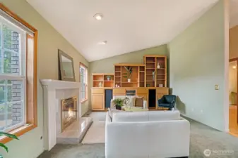 Vaulted ceilings add dimension and airiness, while a wall of custom built-in cabinetry offers abundant storage and display space, perfect for showcasing art, books, or entertaining essentials.