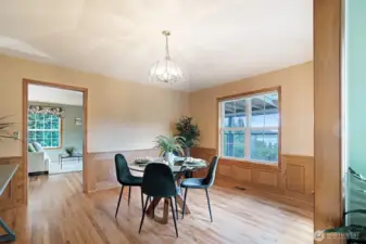 Enjoy dining with a view—this formal dining room features oak hardwood floors, rich wood wainscoting, and a large picture window that perfectly frames peaceful lake views.
