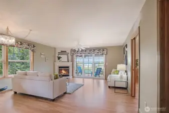 The spacious great room seamlessly connects to the gourmet kitchen and opens to a large covered deck, creating the perfect layout for indoor-outdoor living. Gather around the cozy gas fireplace, framed by custom millwork, or soak in peaceful lake views through a wall of windows and glass doors.