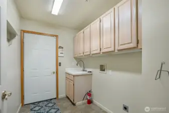Spacious and functional, this large utility room offers abundant cabinet storage, a deep utility sink, perfect for handling daily laundry needs or pet cleanup with ease. Thoughtfully located just off the 3-car garage, it provides a convenient drop zone for busy households.
