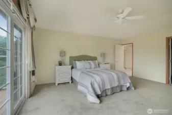 Another view of the Primary suite featuring serene lake views and direct access to a private deck.