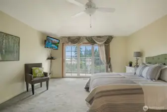 a true sanctuary, offering generous proportions, calming tones, and serene views of the lake through a wall of oversized sliding glass doors. The room easily accommodates a full bedroom suite plus a cozy sitting area.