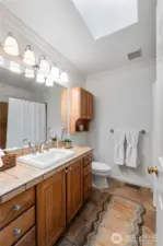 Main full bathroom has a skylight to fill this space with natural light. Beautiful tile floors and counters.