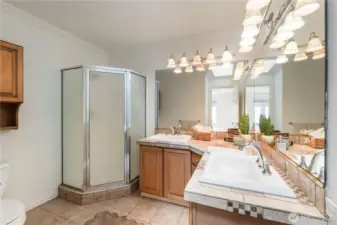 Private primary suite bathroom offers dual vanities and a walk-in shower.