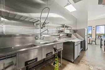 One of the sink stations has 3 sinks and commercial sprayer.