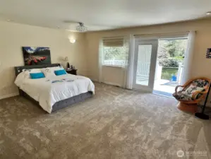 Extra large primary bedroom with french doors leading out to expansive deck with canal views
