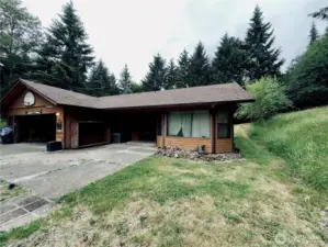 Plenty of parking near the single level home at 818 NW 349th St, La Center WA in Clark County.  Formal living room to the right of the covered front entry porch. Oversize garage on left side of home with access to the home through the laundry room and bonus bathroom area.