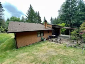 Side yard and view towards covered patio of the single level home at 818 NW 349th St, La Center WA in Clark County.