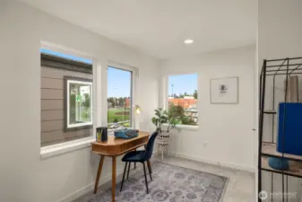 Bright and inspiring, this flex space is perfect for a home office or creative studio, featuring expansive windows that frame peaceful neighborhood views. Photos of home with similar layout, finishes & fixtures.