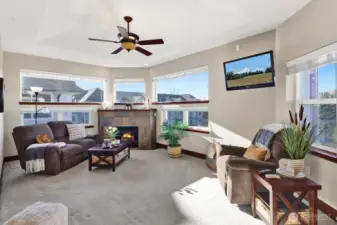 Cozy meets elevated—gas fireplace, nine-foot ceilings topped with a ceiling fan, and a stunning gas fireplace framed by panoramic windows.