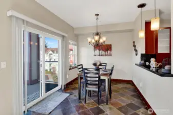 Sunlit dining area with slate floors, seamless access to the lanai, and a pass-through that connects beautifully to the kitchen.