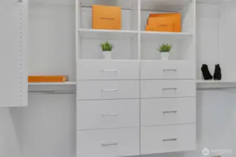 The walk-in closet features custom shelving.