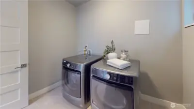 Spacious laundry room with side-by-side washer and dryer.