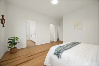 Looking across the primary suite toward the full bath and the large walk-in closet.