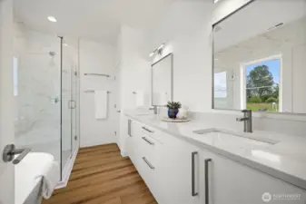 The primary bath has a large dual sink vanity as well as a separate soaking tub and shower. There is also a toilet room at the end of the vanity.