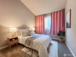 Second bedroom with high vaulted ceilings and large window.