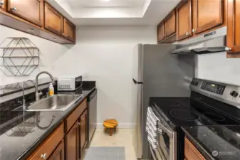 Kitchen with stainless steel appliances, warm wood cabinets and granite counter tops.