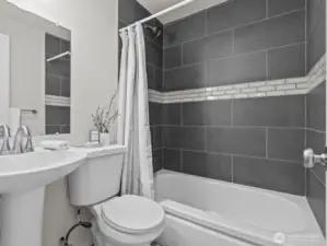 The stylish bathroom features the same flooring as the kitchen and this stunning tile.
