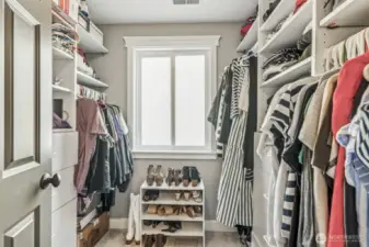 Custom organizers in the walk-in closet help you keep everything in order.