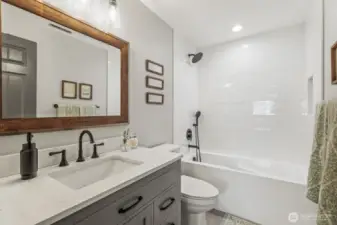 Hallway full bathroom on the upper level - also remodeled in 2021 with a new tub, shower surround, toilet, vanity, hardware and tile floors.