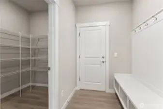 Garage entrance showing the walk in pantry and built in bench for easy drop zone for shoes, groceries and coats. Photos are for example only. Model home of the same plan and may reflect different colors and options.