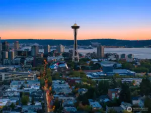 The Space Needle rises, luminous against twilight — a reminder you live in the heart of Seattle’s story.