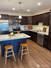 Spacious kitchen with eating bar/island; stainless steel appliances; lots of cabinets with convenient pulls outs in lower cabinets.