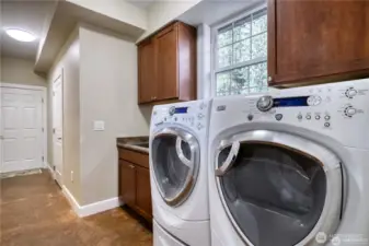 Laundry room has front loading G.E. Profile washer/dryer with steam de-wrinkle function with pedestals. Stainless steel sink with cabinet and cabinets above. Located on the main level.