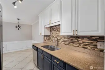 Kitchen: Galley-style kitchen with granite countertops, stainless steel appliances, and abundant cabinet storage. Modern backsplash, tile flooring, and under-cabinet lighting create a stylish and functional cooking space.
