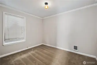 Bedroom: Light-filled bedroom with soft carpeting and crown molding. Neutral tones make this space move-in ready and easy to personalize.