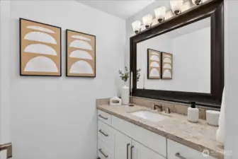 A beautifully appointed full bathroom featuring granite counters, undermount sink, brushed nickel fixtures, white cabinetry, and a generously sized framed mirror — bright, clean, and move-in ready.