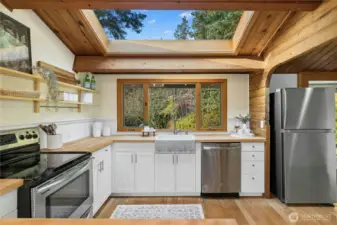 An updated kitchen with charming features like solid butcher block countertops, exposed shelving and a wonderful overhead skylight.
