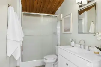 The connected primary bathroom with an over-sized shower, updated flooring and fixtures.