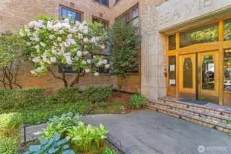 Gorgeous entryway. Unit is behind the camellia bushes depicted here. Hyper convenient building location for pet owners.