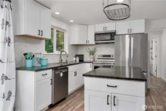 Past the kitchen is the Primary bedroom, bathroom, and utility room